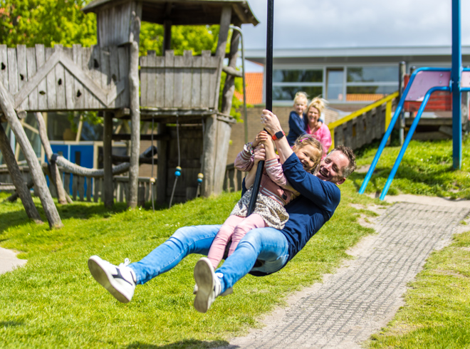 Een gezin spelend in een speeltuin: werken bij GGD fryslan - dan ben je relevant voor iedereen.