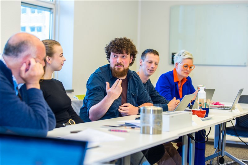 5 collega's praten met elkaar