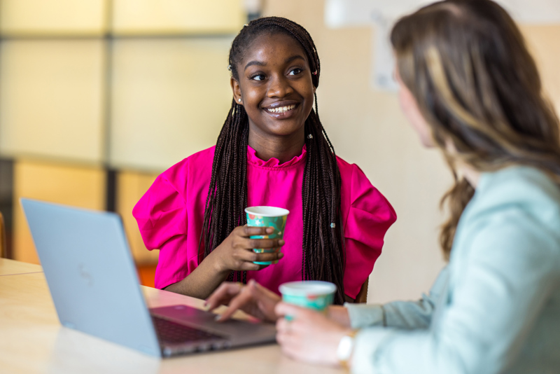 Twee collega's zittend aan tafel in gesprek