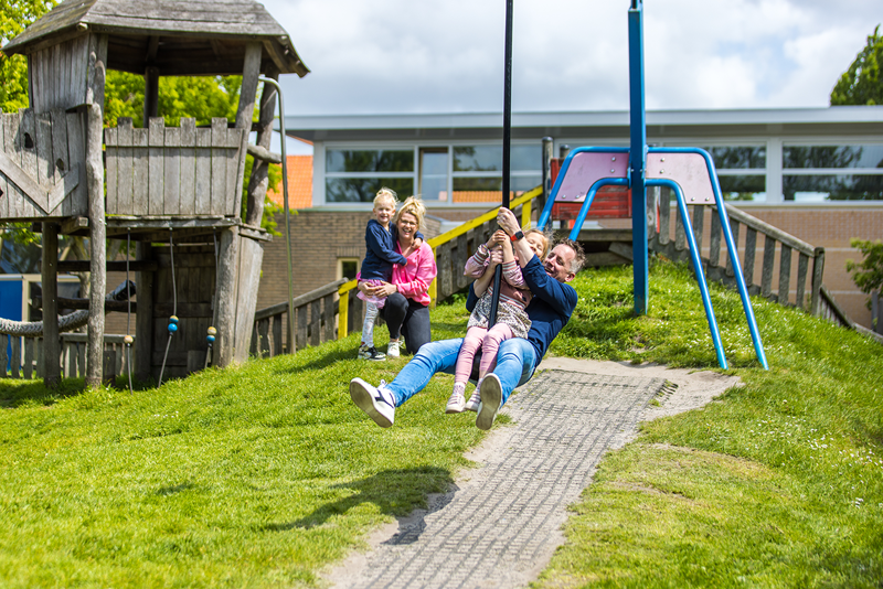 Vader met dochter op de kabelbaan met moeder en andere dochter op de achtergrond